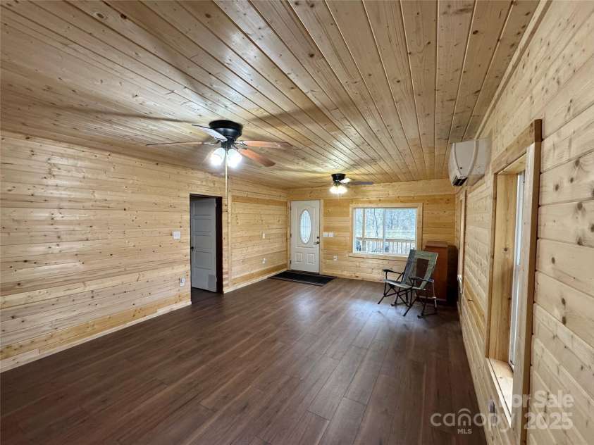 55 Summit View Drive, Marshall, NC 28753.  MLS# CAR4237579, YatesRealty ID 9581. Livingroom toward front door entrance with main bedroom to the left