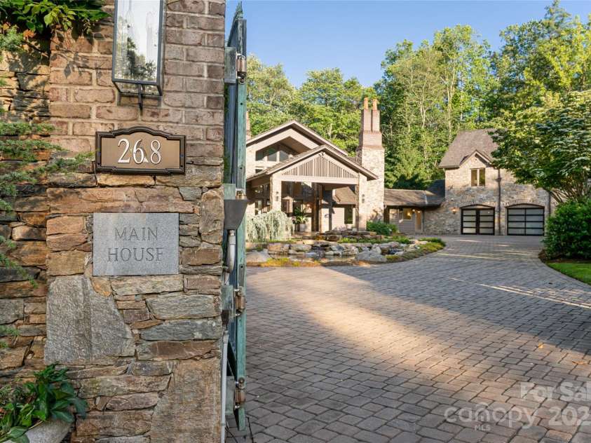 268 Holly Arbor Lane, Asheville, NC 28803.  MLS# CAR4268471, YatesRealty ID 97. Privately gated, the estate features a stately stone wall that lines the entrance, offering both elegance and a sense of arrival as you approach the home.