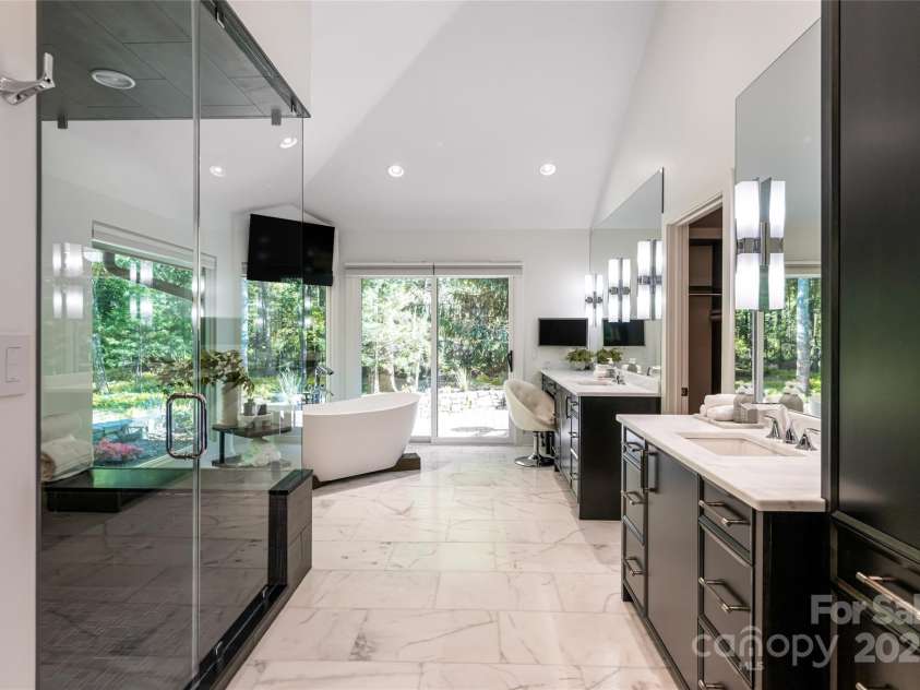 268 Holly Arbor Lane, Asheville, NC 28803.  MLS# CAR4268471, YatesRealty ID 97. The en-suite bath is luxury.  Featuring marble-topped custom vanities, a freestanding soaking tub with forest views, a steam-equipped oversized shower, radiant heated floors, and remote-controlled Hunter Douglas blinds f