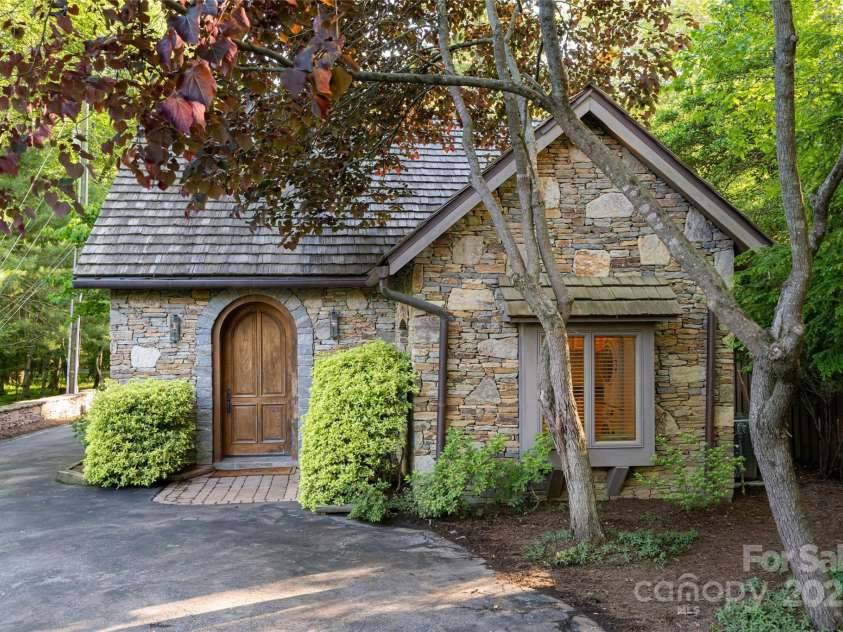 268 Holly Arbor Lane, Asheville, NC 28803.  MLS# CAR4268471, YatesRealty ID 97. The Gate House is bursting with charm, featuring a classic stone exterior, cedar shake roof, and an elegant arched entry door that enhances its timeless, storybook appeal for the guests of this one bedroom guest house.