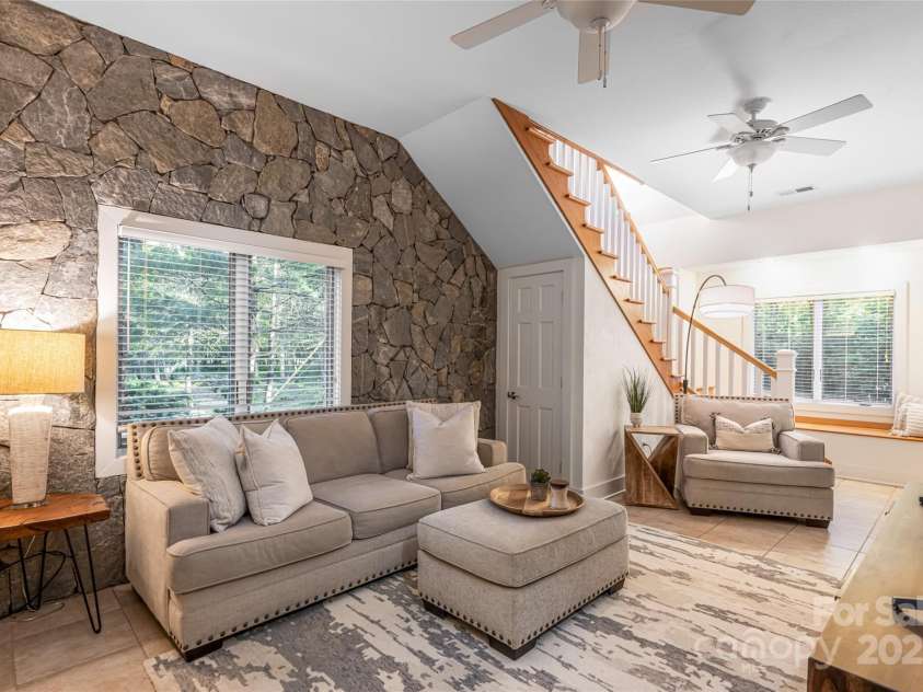 268 Holly Arbor Lane, Asheville, NC 28803.  MLS# CAR4268471, YatesRealty ID 97. The interior of the Gate House is equally enchanting, with a cozy stone accent wall and built-in window seats that invite relaxation and add to its timeless character.