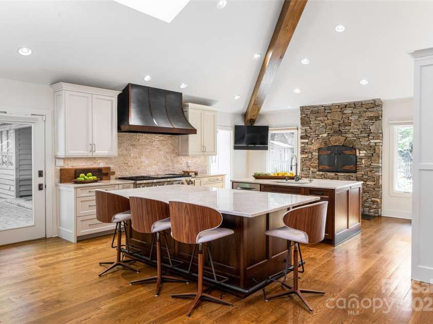 268 Holly Arbor Lane, Asheville, NC 28803.  MLS# CAR4268471, YatesRealty ID 97. The main residence boasts a chef-inspired kitchen equipped with state-of-the-art appliances, custom cabinetry, and a cozy gas fireplace.