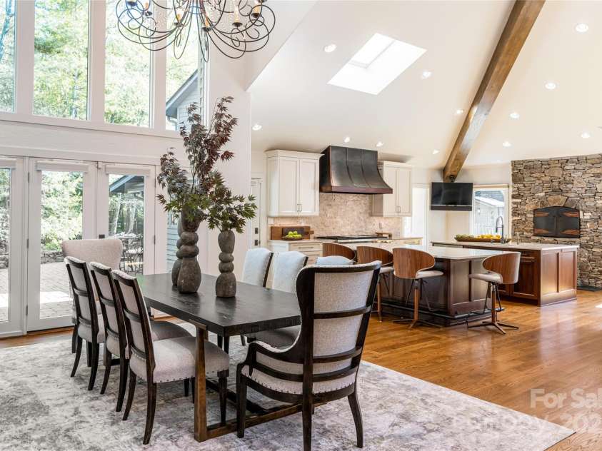 268 Holly Arbor Lane, Asheville, NC 28803.  MLS# CAR4268471, YatesRealty ID 97. The open floor plan design of the great room, dining area, and state-of-the-art chef’s kitchen extends effortlessly onto the expansive exterior stone patio, creating a harmonious blend between indoor luxury and the surro