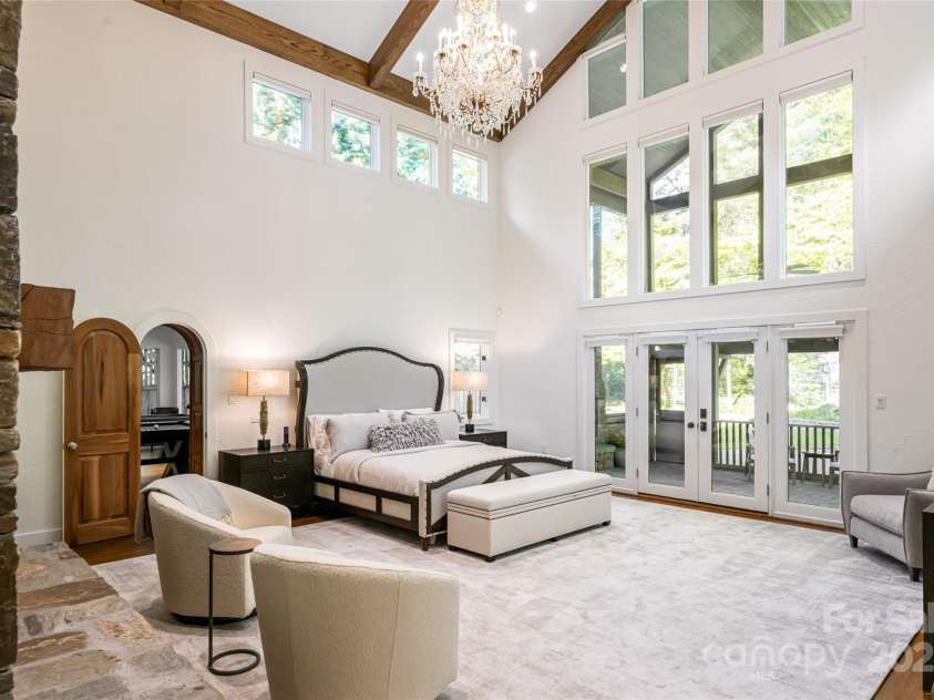 268 Holly Arbor Lane, Asheville, NC 28803.  MLS# CAR4268471, YatesRealty ID 97. The primary suite is a serene retreat, featuring an en-suite bath and dramatic floor-to-ceiling stone fireplace with gas insert.  Step out to your private screened-in patio with a second stone fireplace.