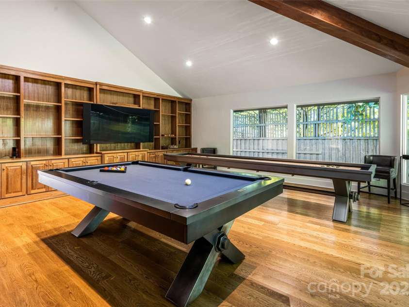 268 Holly Arbor Lane, Asheville, NC 28803.  MLS# CAR4268471, YatesRealty ID 97. The spacious game room, located just off the great room, showcases custom built-ins, floor-to-ceiling windows, and is outfitted with both a shuffleboard and billiards table.