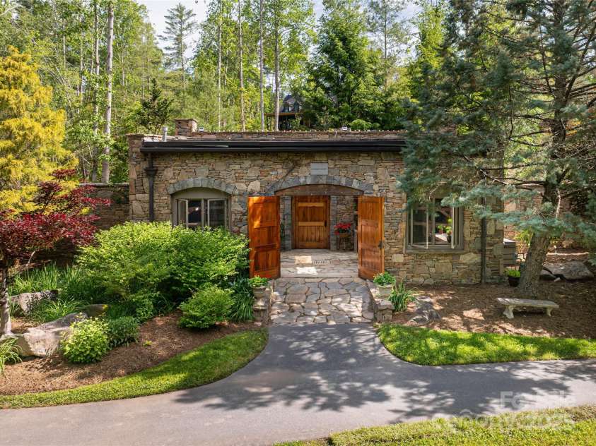 268 Holly Arbor Lane, Asheville, NC 28803.  MLS# CAR4268471, YatesRealty ID 97. The storybook stone conservancy, steeped in old-world charm, is a cherished retreat nestled among vibrant gardens and overlooking a tranquil meadow.