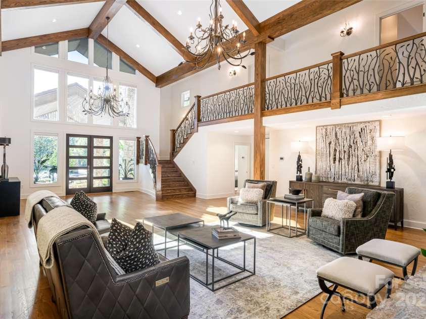 268 Holly Arbor Lane, Asheville, NC 28803.  MLS# CAR4268471, YatesRealty ID 97. Upon entering the Main House, the great room welcomes you with its post-and-beam design, soaring ceilings, and a floor-to-ceiling stone fireplace. Custom-forged iron handrails add a touch of local craftsmanship.