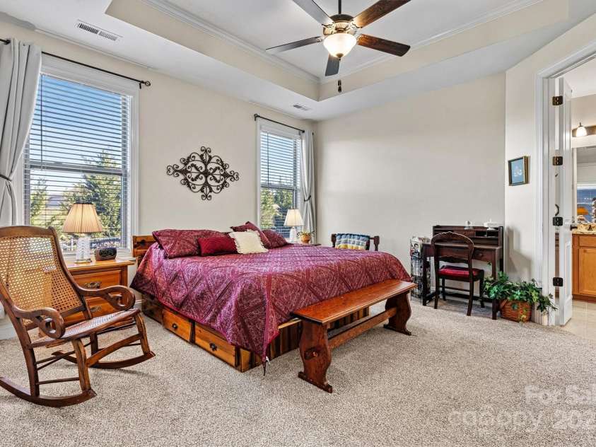 7029 Overjoyed Crossing, Charlotte, NC 28215.  MLS# CAR4212396, YatesRealty ID 9751. The spacious Primary bedroom features tray ceiling, upgraded carpet & pad, abundant natural light filtered through custom blinds, ceiling fan and TWO closets!