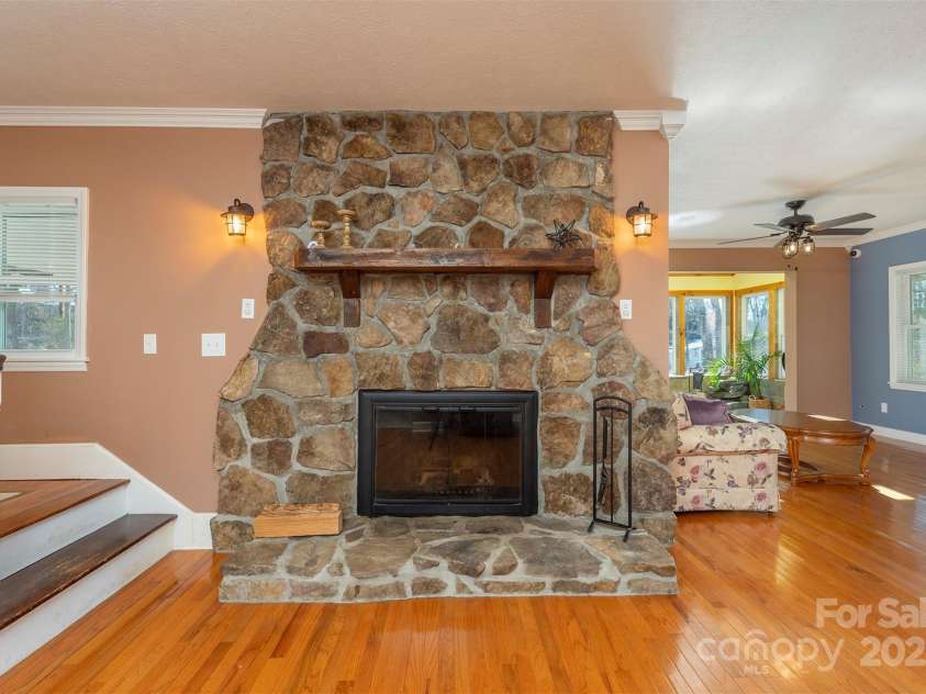 1740 Haywood Road, Hendersonville, NC 28791.  MLS# CAR4226897, YatesRealty ID 977. Located in the den, inviting rock fireplace with easy lighting and natural gas for cozy ambiance.