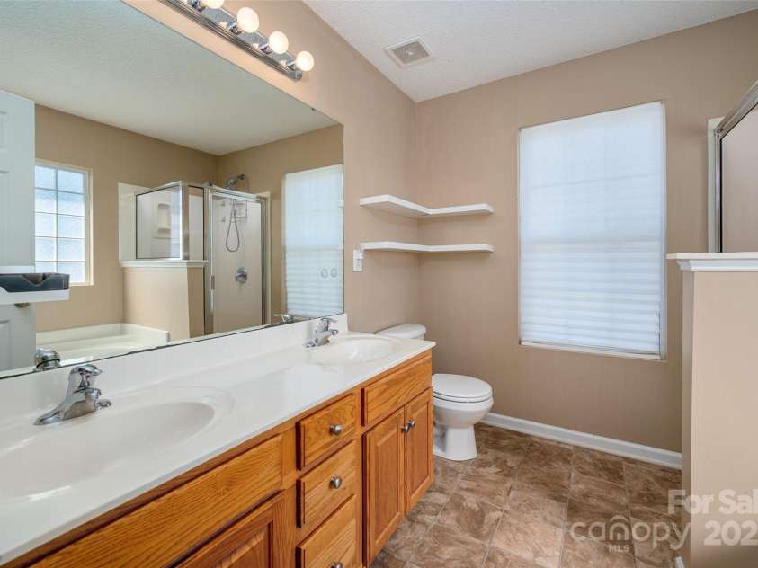 6934 Tanners Creek Drive, Huntersville, NC 28078.  MLS# CAR4303299, YatesRealty ID 9819. Dual sinks in the primary en-suite with open shelving for additional storage and decor