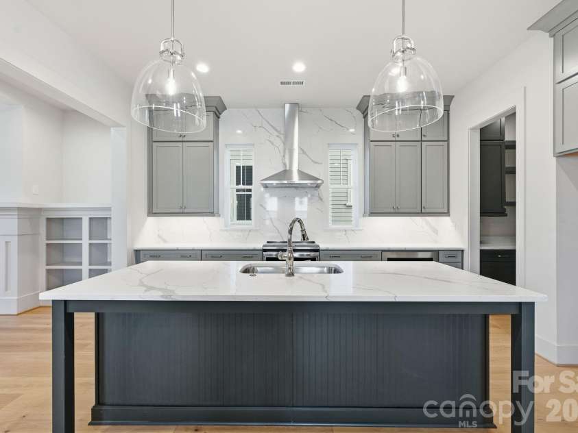 7245 Westrow Avenue, Charlotte, NC 28278.  MLS# CAR4314661, YatesRealty ID 982. Gourmet kitchen with large center island, quartz countertops and modern vent hood. This gathering space is perfect for entertaining.