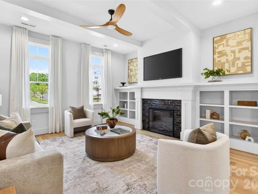 7245 Westrow Avenue, Charlotte, NC 28278.  MLS# CAR4314661, YatesRealty ID 982. Inviting family room showcasing a fireplace flanked by custom built-ins. Ceiling beams and warm hardwood floors make this space perfect for entertaining or everyday living.