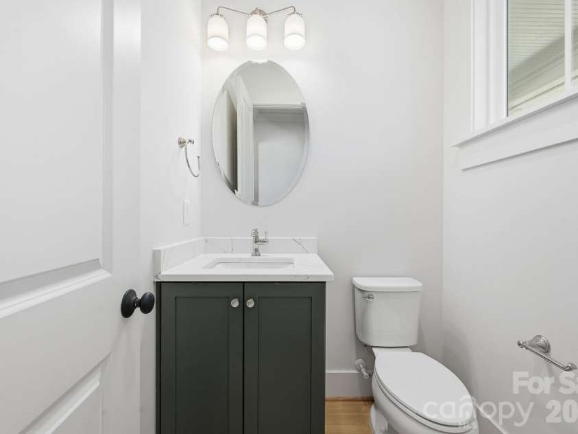 7245 Westrow Avenue, Charlotte, NC 28278.  MLS# CAR4314661, YatesRealty ID 982. Powder room featuring a custom vanity cabinet with elegant finishes and a window that fills the space with natural light. 