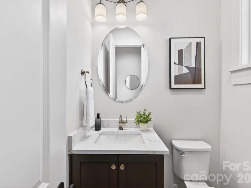 7245 Westrow Avenue, Charlotte, NC 28278.  MLS# CAR4314661, YatesRealty ID 982. Powder room featuring a custom vanity cabinet with elegant finishes and a window that fills the space with natural light.