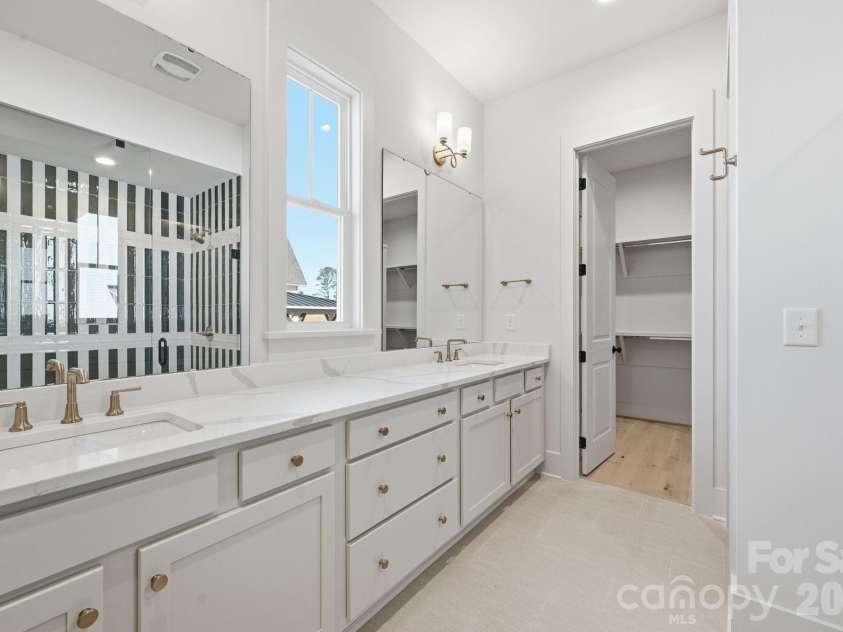 7245 Westrow Avenue, Charlotte, NC 28278.  MLS# CAR4314661, YatesRealty ID 982. Primary bath with dual sinks and quartz countertops. A fully frameless glass shower features a stunning tile surround.