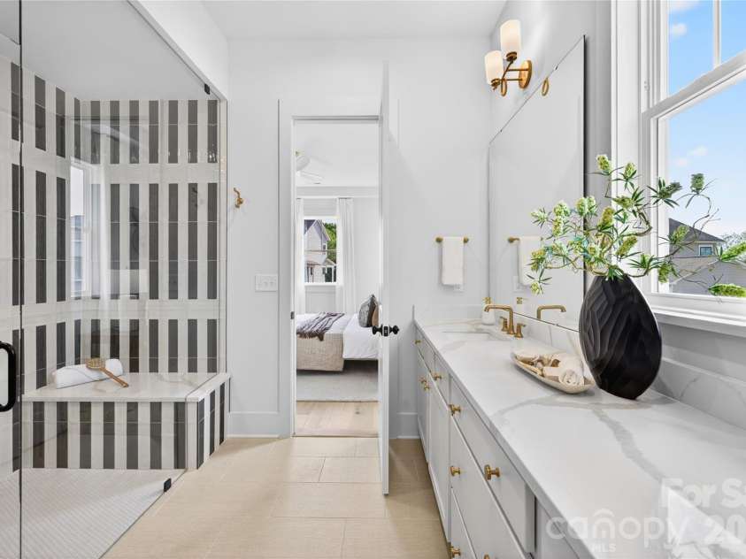 7245 Westrow Avenue, Charlotte, NC 28278.  MLS# CAR4314661, YatesRealty ID 982. Primary bath with dual sinks and quartz countertops. A fully frameless glass shower features a stunning tile surround.