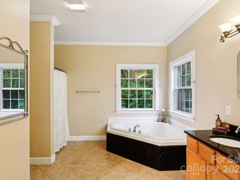 165 Sequoyah Drive, Waynesville, NC 28785.  MLS# CAR4249875, YatesRealty ID 9884. Luxurious tub in the primary bath for rest and relaxation