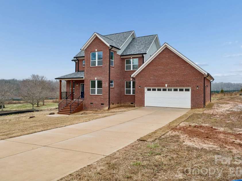 114 Strawberry Court, Lincolnton, NC 28092.  MLS# CAR4352512, YatesRealty ID 9926. Exterior front offers 3 sides brick, extensive concrete driveway for parking and an amazing covered front porch that features rout-iron railing and cedar columns