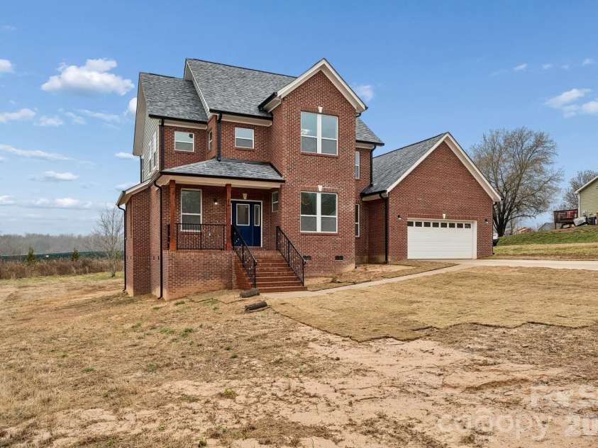 114 Strawberry Court, Lincolnton, NC 28092.  MLS# CAR4352512, YatesRealty ID 9926. Exterior front offers 3 sides brick, extensive concrete driveway for parking and an amazing covered front porch that features rout-iron railing and cedar columns