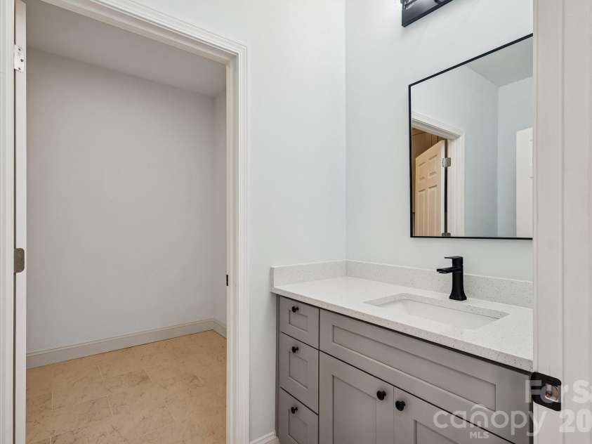 114 Strawberry Court, Lincolnton, NC 28092.  MLS# CAR4352512, YatesRealty ID 9926. Powder room on first floor with quartz counter top, framed mirror, elegant light fixtures, tile floor and access to the laundry room