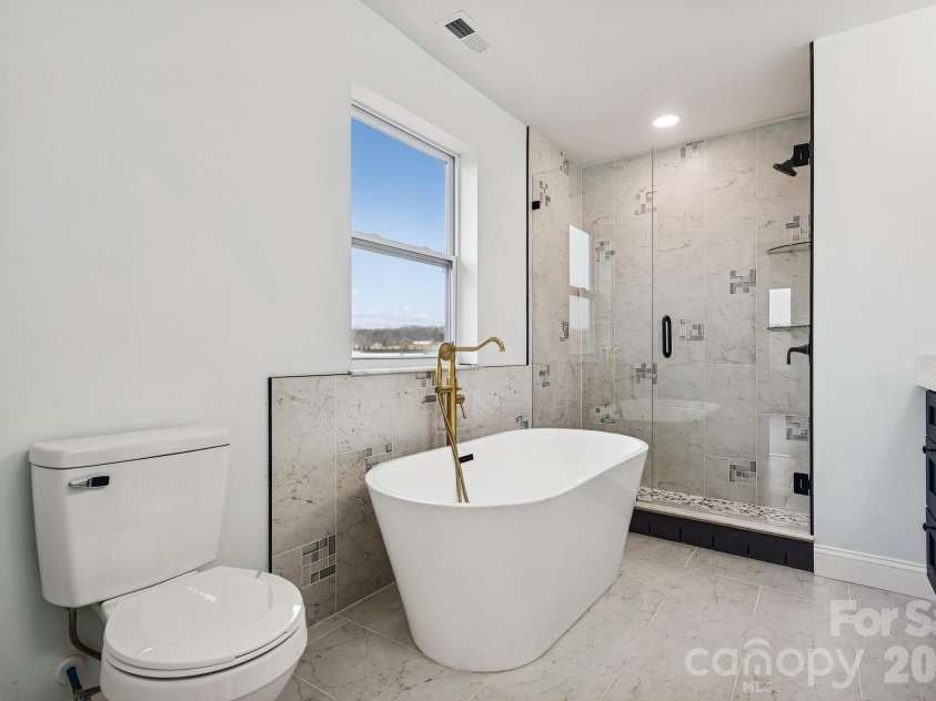 114 Strawberry Court, Lincolnton, NC 28092.  MLS# CAR4352512, YatesRealty ID 9926. Primary bedroom bathroom suite with his and hers sinks, makeup bar, soaking tub and tile walk-in shower