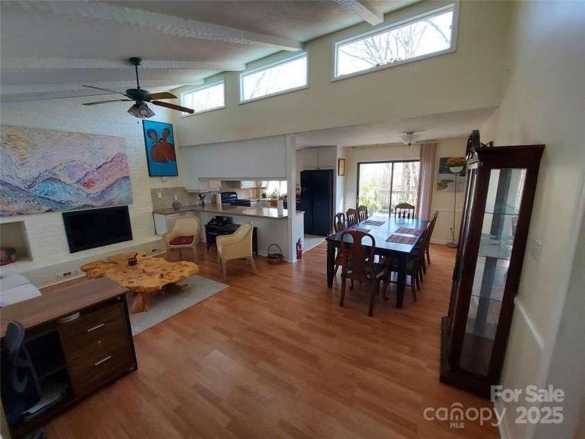 8015 Sullivan Drive, Charlotte, NC 28215.  MLS# CAR4223466, YatesRealty ID 9926. Light filled living room thanks to gabled transom windows. Note Ceiling fan and brick fireplace!