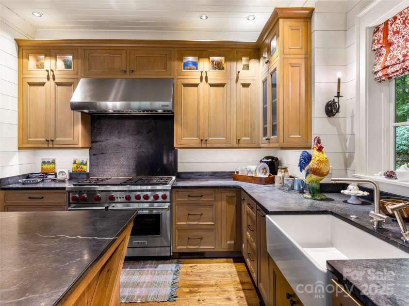 616 Old Growth Forest Road, Burnsville, NC 28714.  MLS# CAR4076276, YatesRealty ID 997. ...the apron front farmhouse sink, the Wolf range, the lit cabinetry...